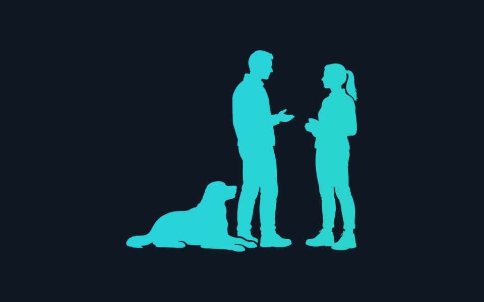 Two people facing one another with a seated dog beside them.